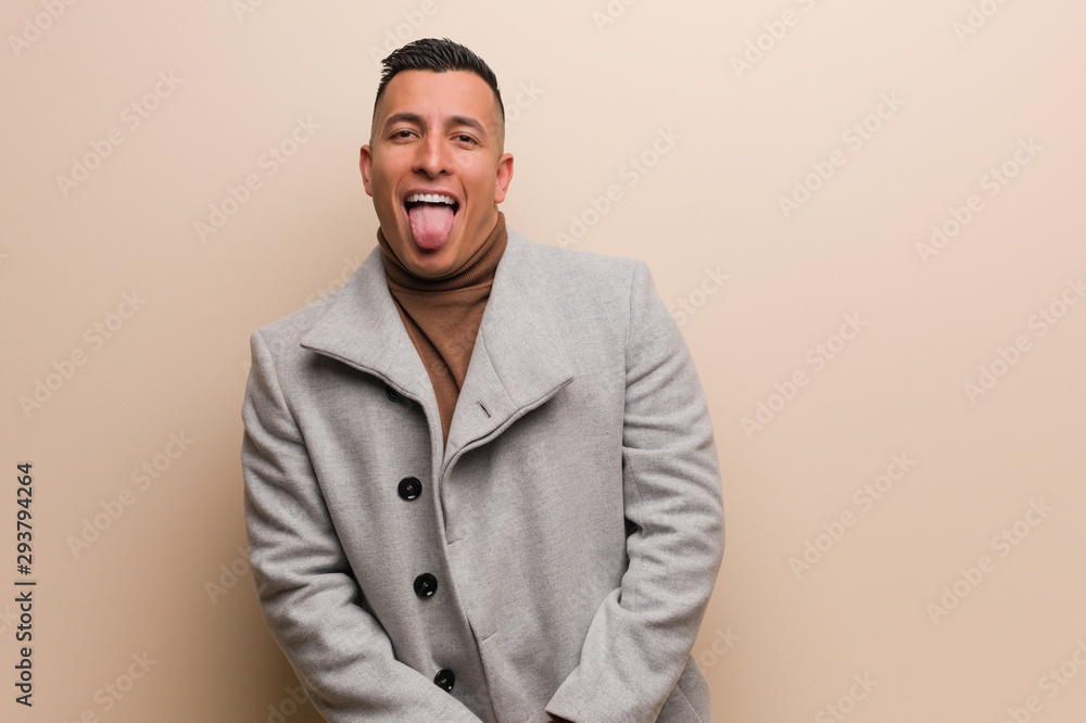 Young latin business man funnny and friendly showing tongue - obrazy, fototapety, plakaty 