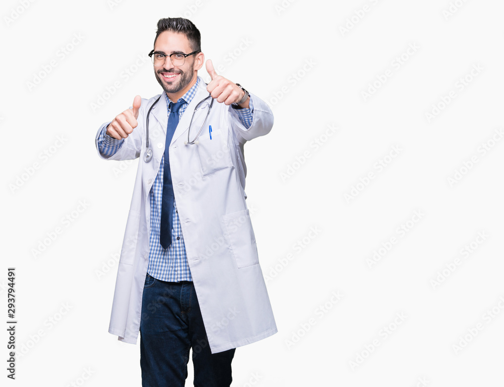 Handsome young doctor man over isolated background approving doing positive gesture with hand, thumbs up smiling and happy for success. Looking at the camera, winner gesture. Handsome young doctor man over isolated background approving doing positive gesture with hand, thumbs up smiling and happy for success. Looking at the camera, winner gesture.