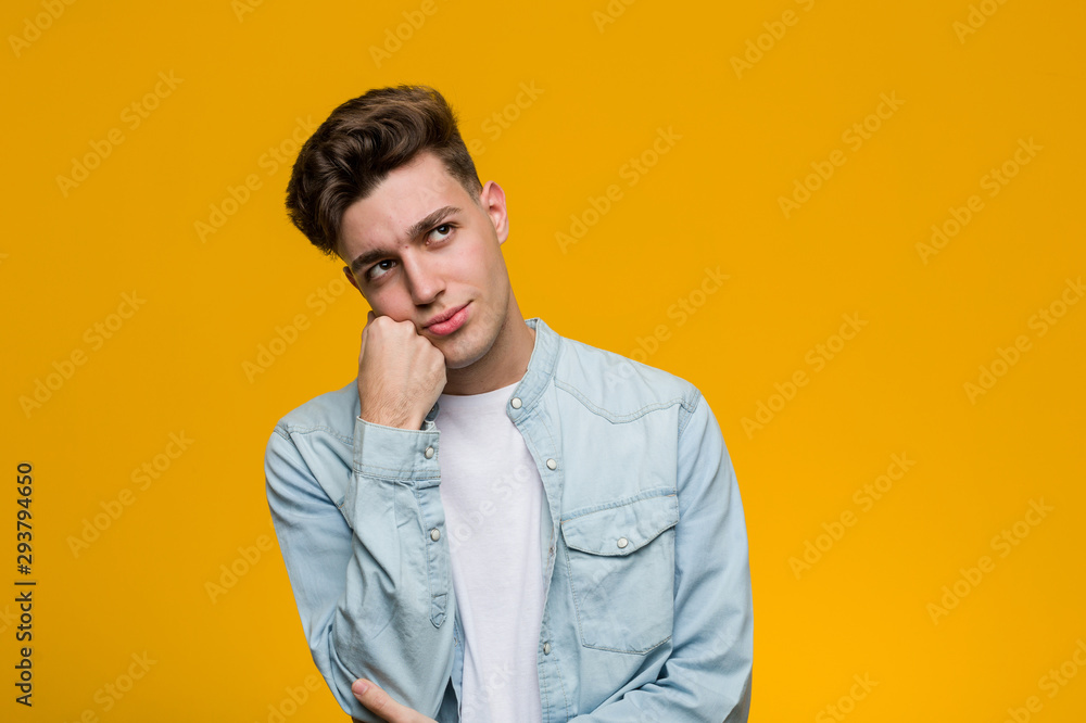 Young handsome student wearing a denim shirt who feels sad and pensive, looking at copy space. Young handsome student wearing a denim shirt who feels sad and pensive, looking at copy space.