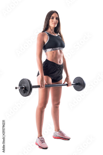 Young fitness woman in black top and shorts posing with barbell. Full body isolated on white background. 