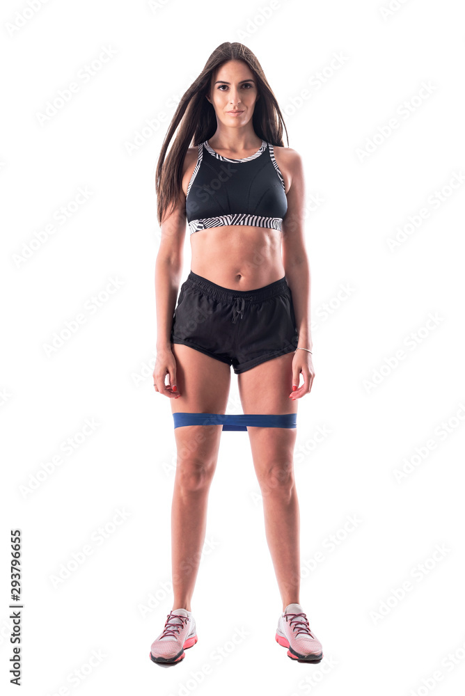 Proud athletic gym girl with great abs in top and shorts with resistance bands on legs. Full body isolated on white background. Proud athletic gym girl with great abs in top and shorts with resistance bands on legs. Full body isolated on white background.