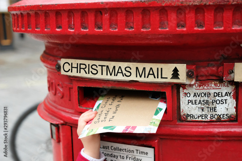 Canvas Print Child is posting a letter for Santa Claus into the Christmas english postbox