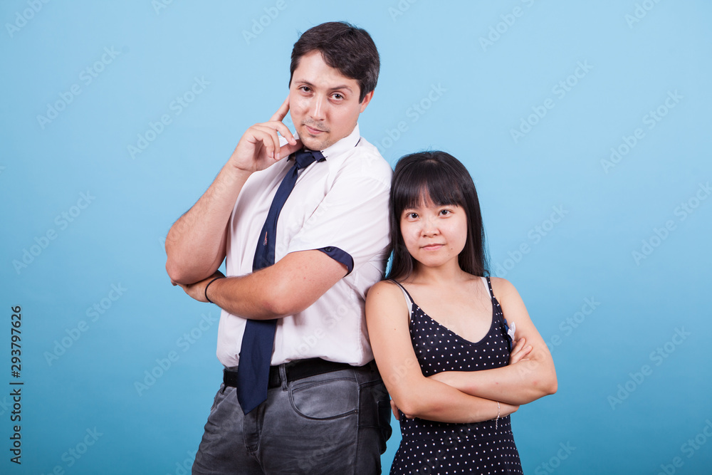 Naklejka premium Cheerful young interracial couple looking at the camera in studio