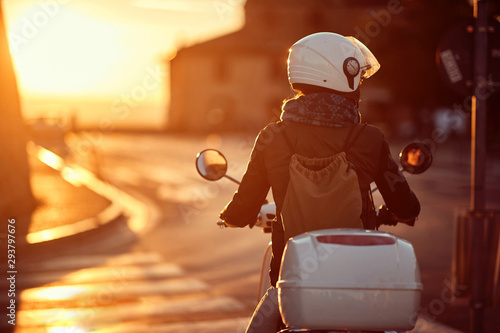 Foto Woman on scooter. girl riding motor scooter on road..