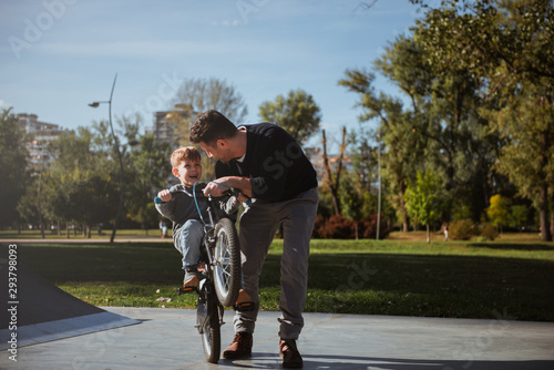 Father Learning his son to ride a bicycle 