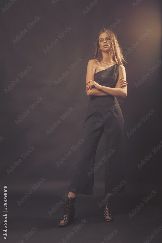 Fashionable girl in golden gray tones in studio. Woman with unflappable face. Lifestyle concept in fashion world Fashionable girl in golden gray tones in studio. Woman with unflappable face. Lifestyle concept in fashion world