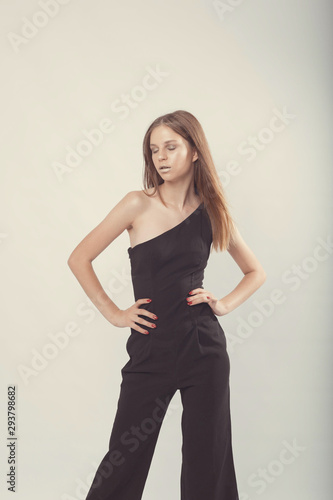 Fashionable girl in light tones in studio. Woman with unflappable face. Lifestyle concept in fashion world. Female in suit