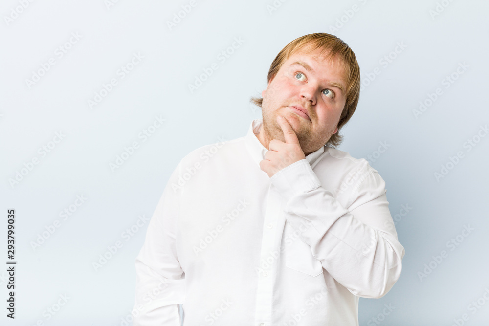 Young authentic redhead fat man looking sideways with doubtful and skeptical expression. Young authentic redhead fat man looking sideways with doubtful and skeptical expression.