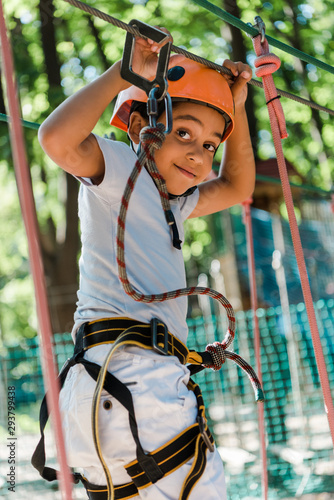 selective focus of cute african american boy with height equipment on high rope trail