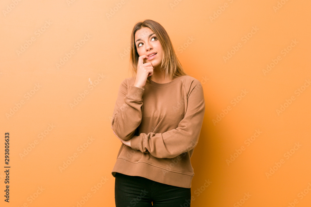 Young authentic charismatic real people woman against a wall relaxed thinking about something looking at a copy space. Young authentic charismatic real people woman against a wall relaxed thinking about something looking at a copy space.