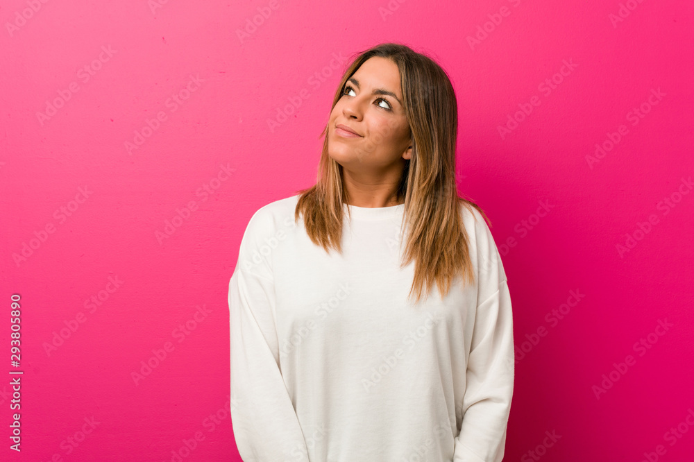Young authentic charismatic real people woman against a wall dreaming of achieving goals and purposes Young authentic charismatic real people woman against a wall dreaming of achieving goals and purposes