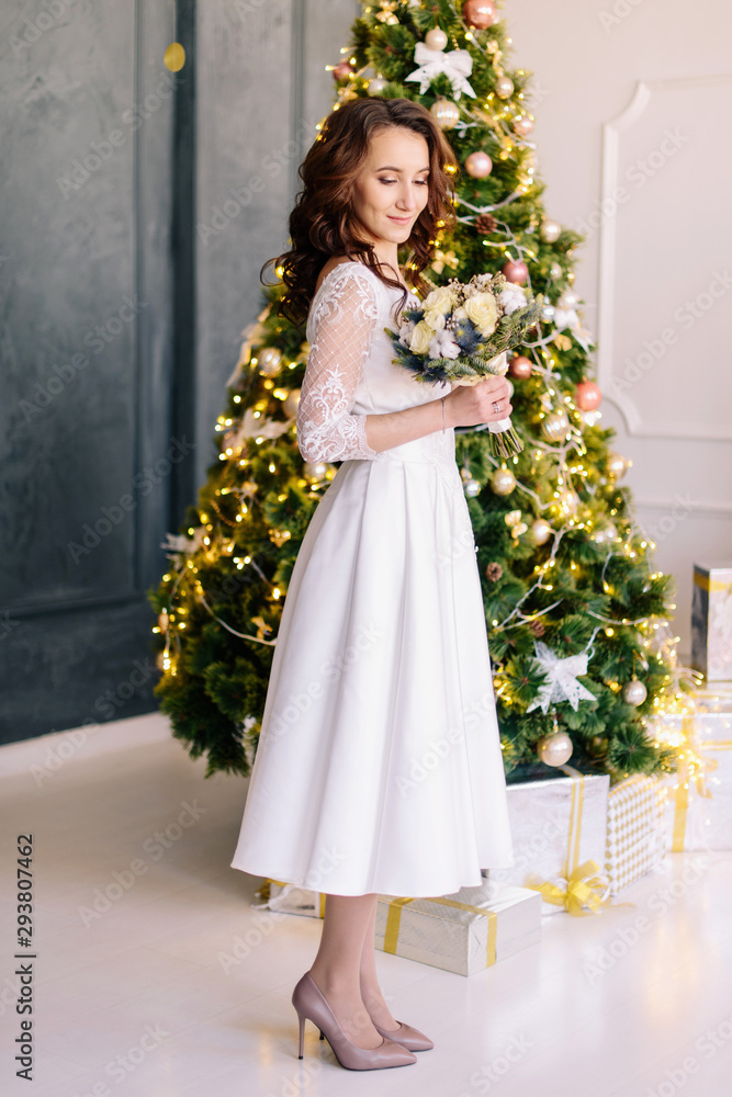 The bride holds in her hands a beautiful winter wedding bouquet. The bride in a beautiful wedding dress. Winter wedding The bride holds in her hands a beautiful winter wedding bouquet. The bride in a beautiful wedding dress. Winter wedding