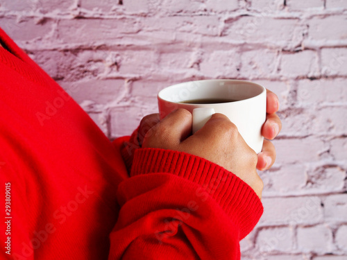  Woman hand in red sweater hold white cup of coffee.. © Ben_24