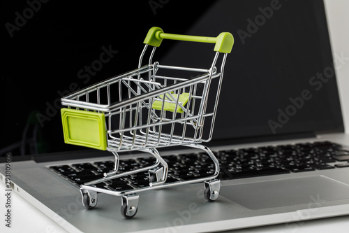 Online shopping and e-Commerce. Basket and laptop on white background.