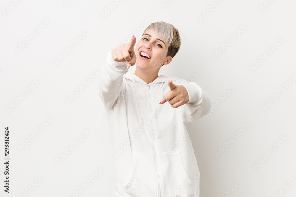 Young curvy woman wearing a white hoodie cheerful smiles pointing to front. Young curvy woman wearing a white hoodie cheerful smiles pointing to front.