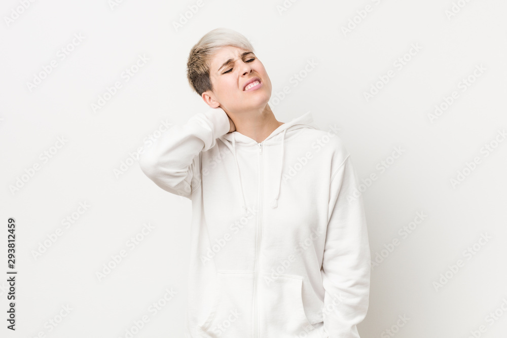 Young curvy woman wearing a white hoodie suffering neck pain due to sedentary lifestyle. Young curvy woman wearing a white hoodie suffering neck pain due to sedentary lifestyle.