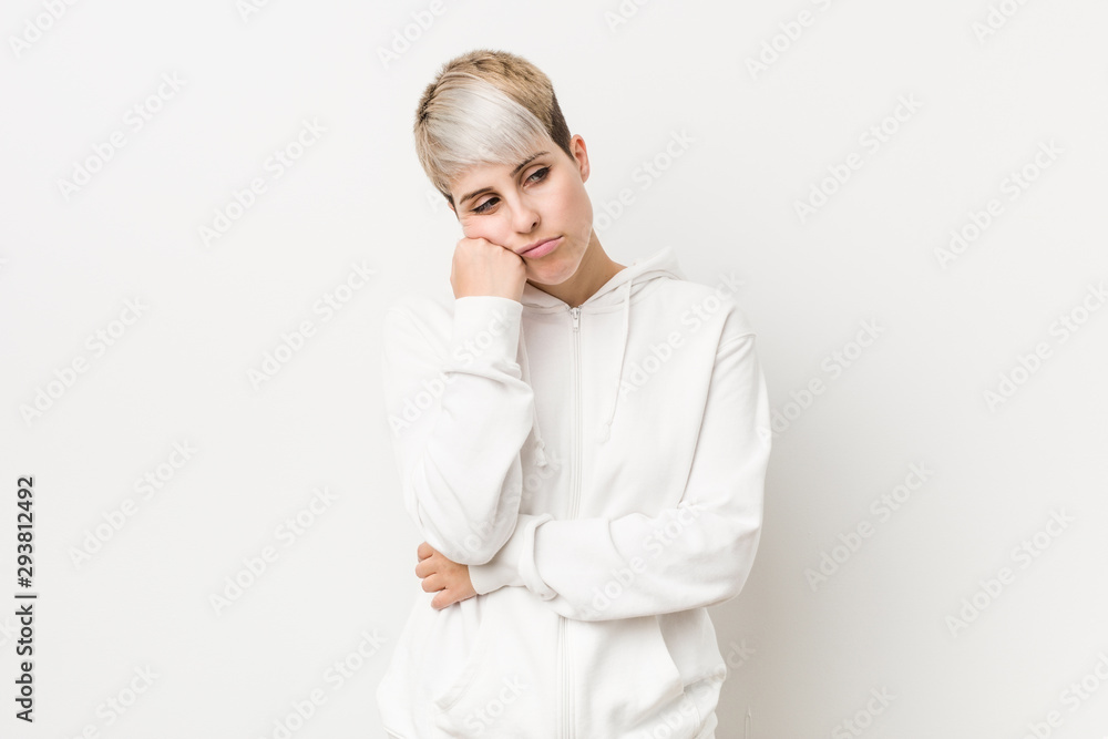 Young curvy woman wearing a white hoodie who feels sad and pensive, looking at copy space. Young curvy woman wearing a white hoodie who feels sad and pensive, looking at copy space.