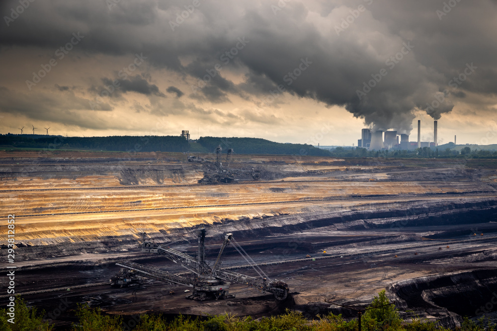 Mining equipment in a brown coal open-pit mine and a power plant with emission.