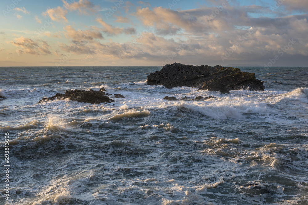 Large waves crash over rocks in stormy seas at Hartland, North Devon, England.