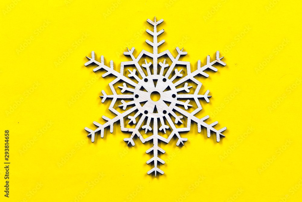 Variations of a decorative snowflake made of plywood on a yellow background. Christmas decorative elements Variations of a decorative snowflake made of plywood on a yellow background. Christmas decorative elements