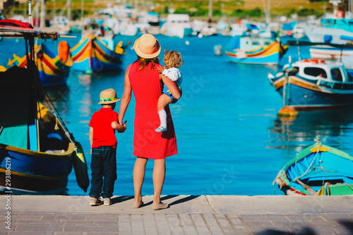 mother and kids looking at traditional boats in Malta