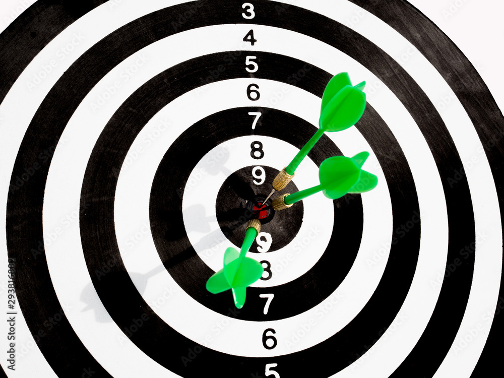 Target with three green dart focus on bull's eye, Setting challenging business goals And ready to achieve the goal with teamwork concept Target with three green dart focus on bull's eye, Setting challenging business goals And ready to achieve the goal with teamwork concept