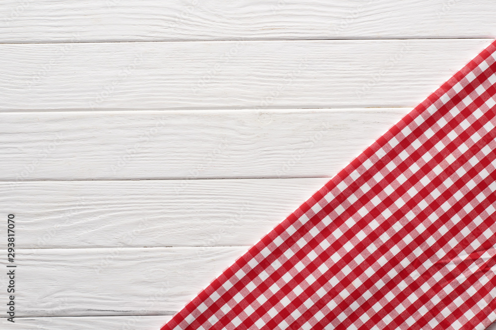 top view of checkered red napkin at white wooden table top view of checkered red napkin at white wooden table