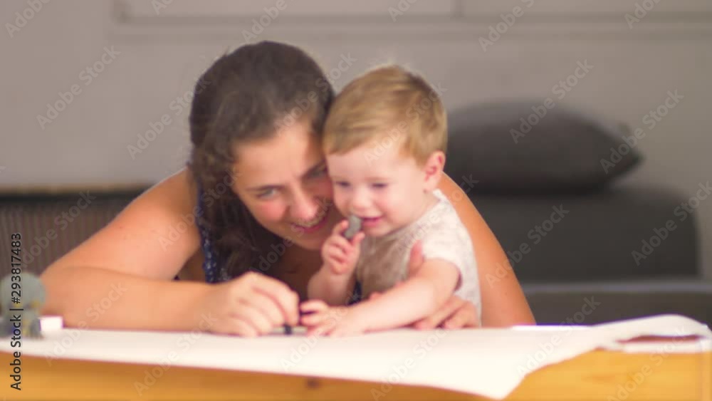 A mother playing with his little baby son of one year old, blue eyes, blonde hair, smiling and enjoying together A mother playing with his little baby son of one year old, blue eyes, blonde hair, smiling and enjoying together