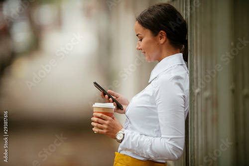 Young businesswoman using phone on coffee break