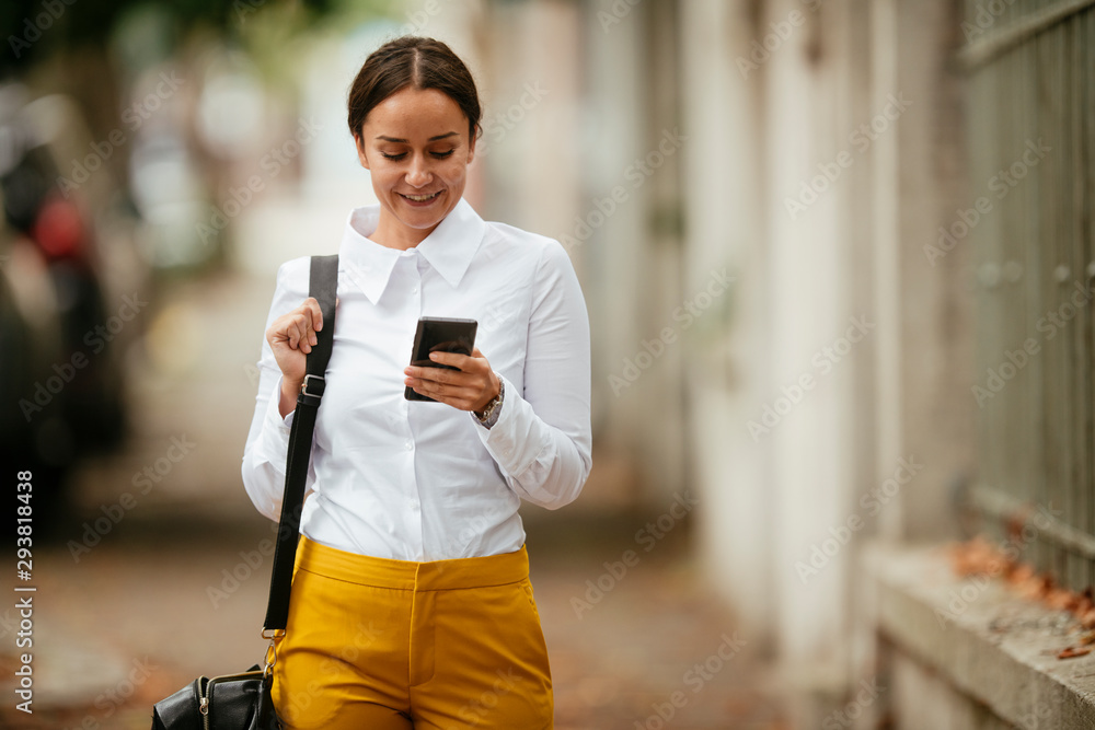 Young woman walking on the street using phone Young woman walking on the street using phone