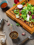 Closeup of a beautiful wooden cutting board with a knife on a wooden background