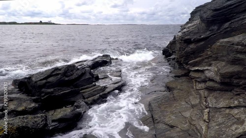 waves from the ocean hitting the rocky shore photo