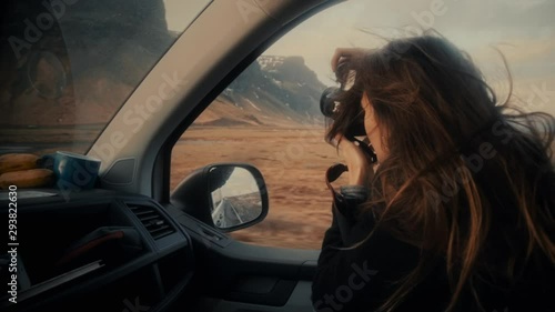 Female taking photos by camera from car