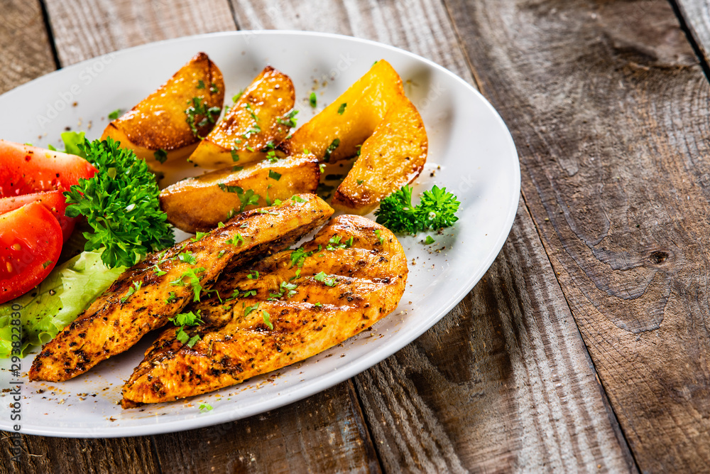 Grilled chicken fillet and vegetableson white plate Grilled chicken fillet and vegetableson white plate