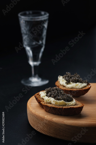Sandwich with black caviar on black background