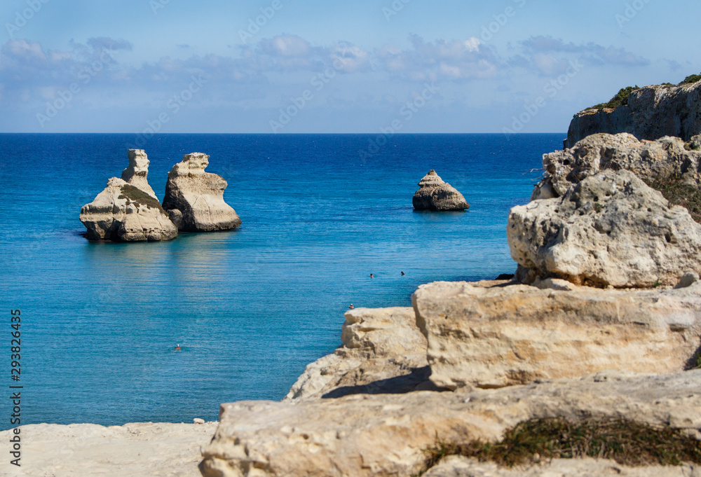 The Two Sisters stacks in front of the shore of Torre dell'Orso
