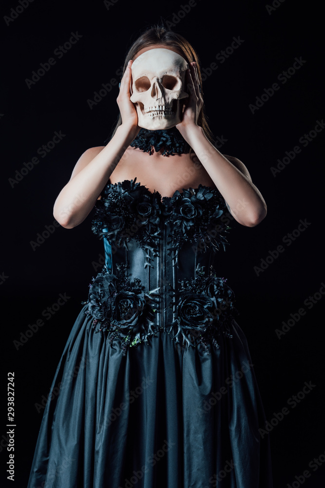 scary vampire girl in black gothic dress holding human skull in front of face isolated on black scary vampire girl in black gothic dress holding human skull in front of face isolated on black