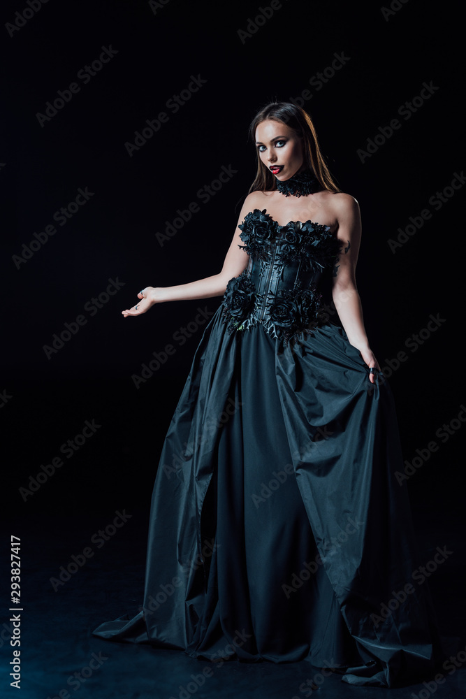 scary vampire girl in black gothic dress pointing with hand on black background scary vampire girl in black gothic dress pointing with hand on black background