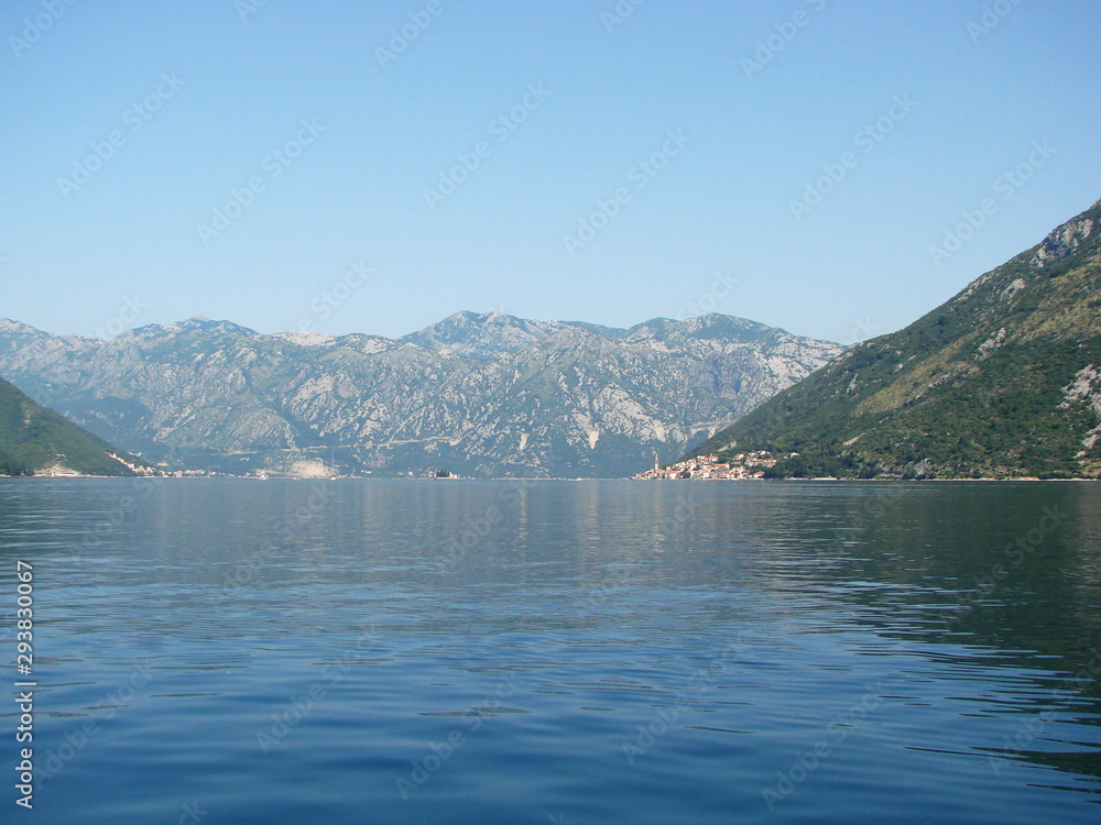 Panorama of the mirror blue surface of the Gulf that reflects the rocky hills on its shores and clear morning skies.