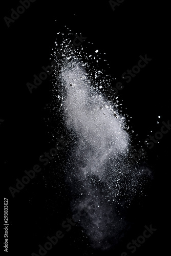 White powder splash isolated on black background. Flour sifting on a black background. Explosive powder white