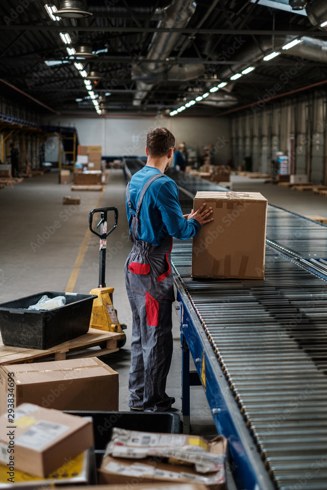 Fototapeta premium Warehouse worker working on a conveyor line
