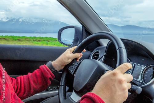 Male hands on steering wheel, closeup