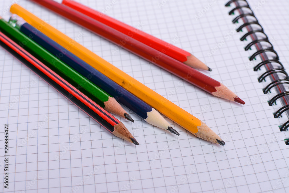 Colorful pencils on white sheet of paper Colorful pencils on white sheet of paper
