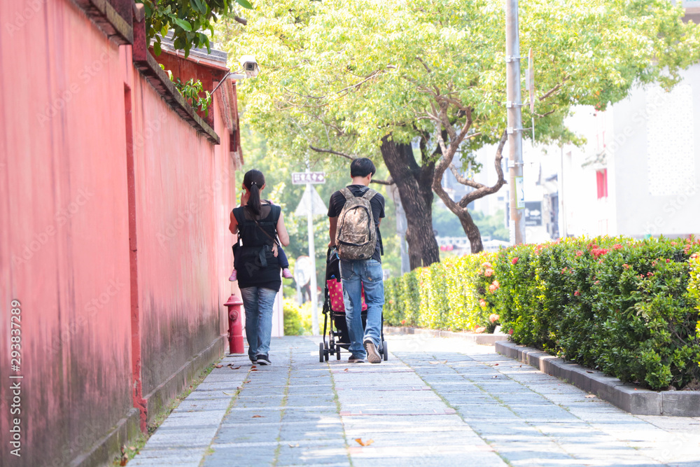 Nuclear family /couple with baby walking beside Taiwan historic site / Confucius Temple in Tainan, Taiwan.
