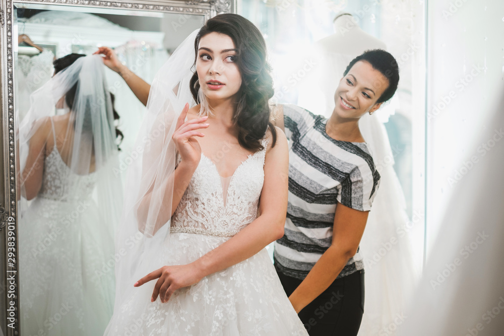 Beautifu bride choosing wedding dress in a wedding salon Beautifu bride choosing wedding dress in a wedding salon