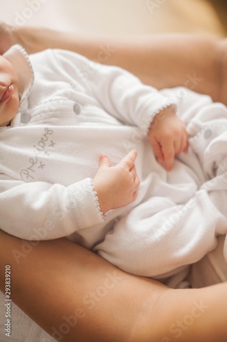 Close-up. The handle of the baby in mother s hands. Cute newborn baby sleeping in mother s arms. Motherhood.