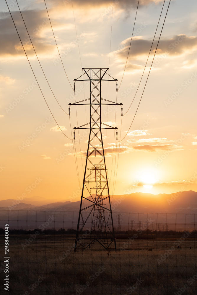 Electric transmission lines against a background of sunset over mountains