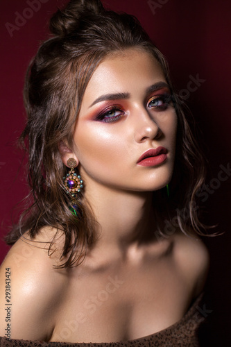 Attractive young model colorful trendy smoky eyes  bright blue eyes  wet hairdo and fashion earring