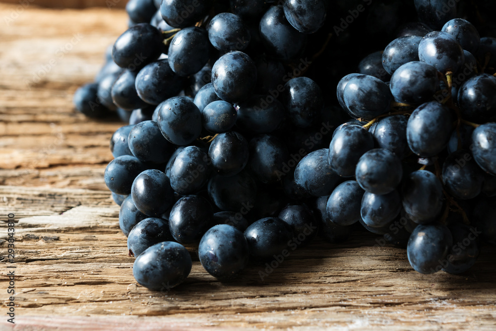 bunches of ripe black grapes on a wooden background
