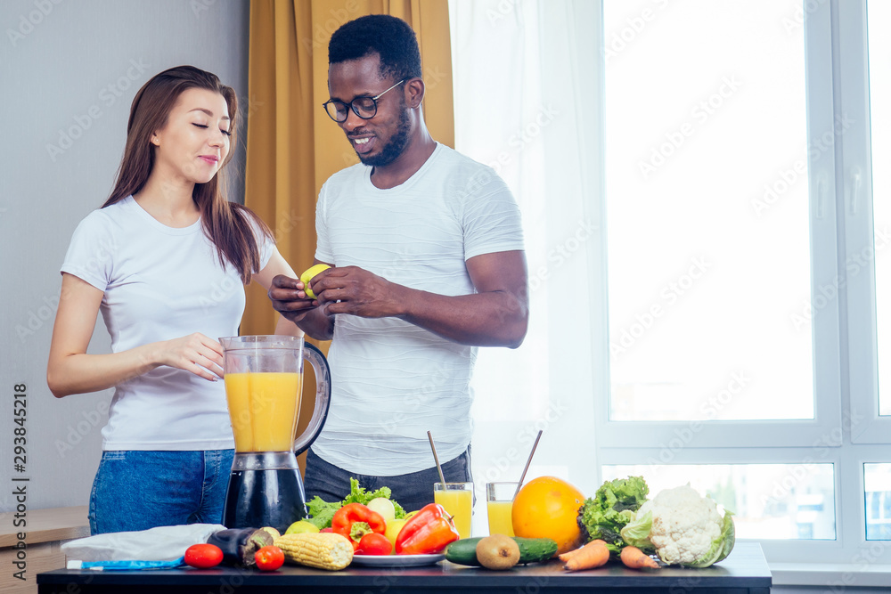 african american man with asian woman making smoothie at home, useing eco tubes from metall african american man with asian woman making smoothie at home, useing eco tubes from metall